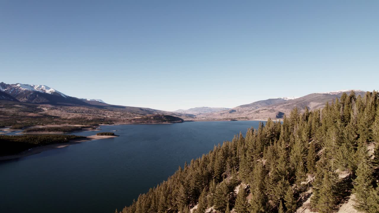 volando a través de la ladera de la ladera de la montaña del pino junto al lago de coníferas que revela el lago en sapphire point, colorado