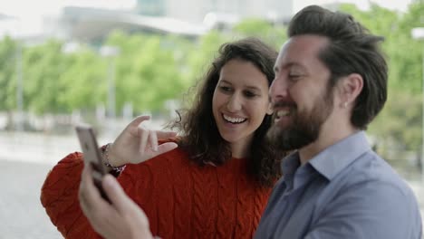 Pareja-Feliz-Teniendo-Video-Chat-A-Través-De-Un-Teléfono-Inteligente-Al-Aire-Libre