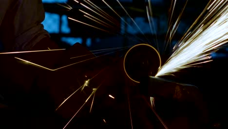 la ingeniería joven está cortando metal con un molinillo angular en el taller