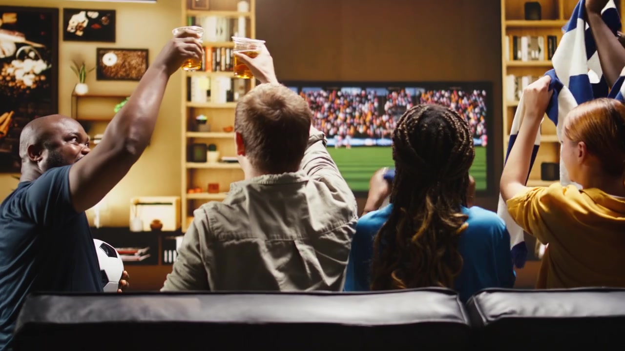 Tifosi di calcio felici a casa brindano con boccali di birra dopo un risultato positivo della partita