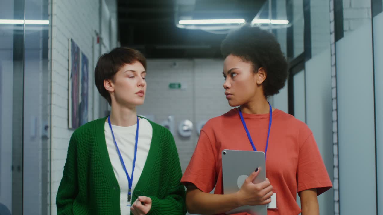 현대적 인 사무실 복도 에서 대화 하는 두 여자