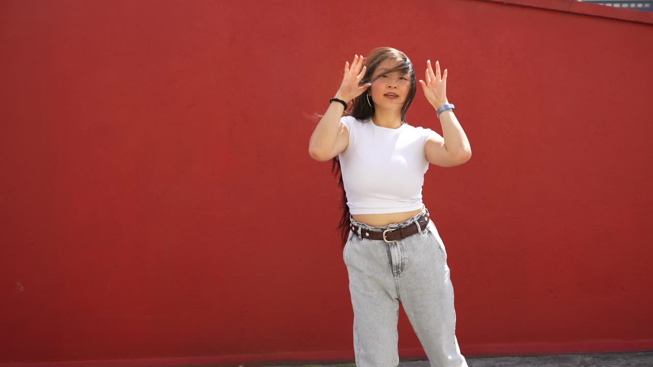 Woman Dancing in Front of Red Wall
