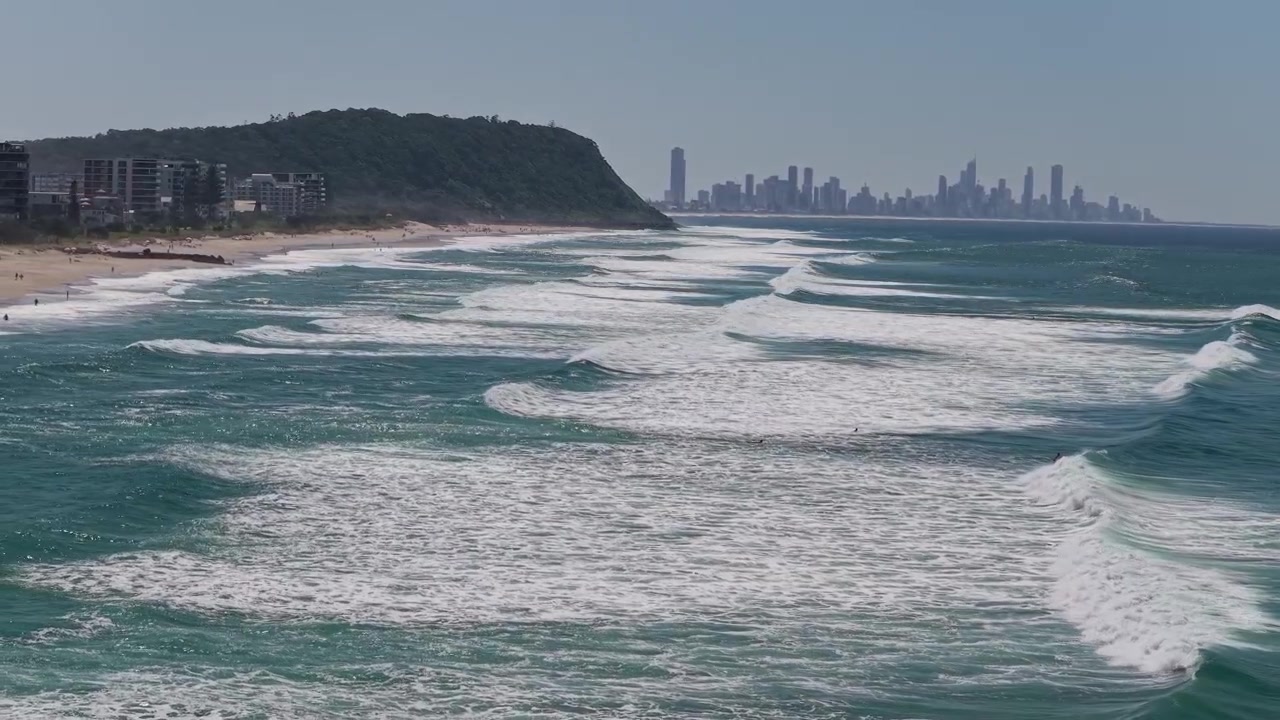 Paesaggio idilliaco dell'oceano, del monte Burleigh e dello skyline di Surfers Paradise sullo sfondo in Australia - Ripresa con drone.