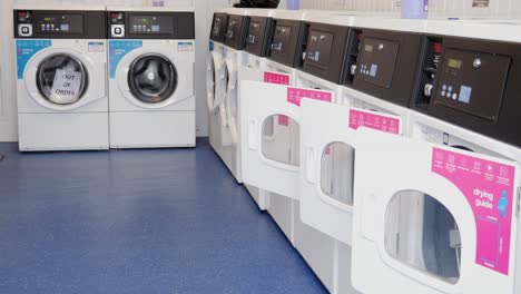 Laundromat-launderette-with-row-of-washing-machines-at-low-angle