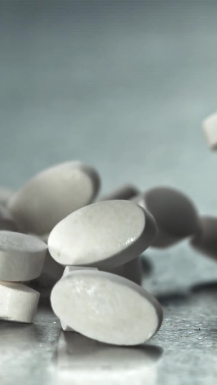 Pillole mediche bianche che cadono al rallentatore