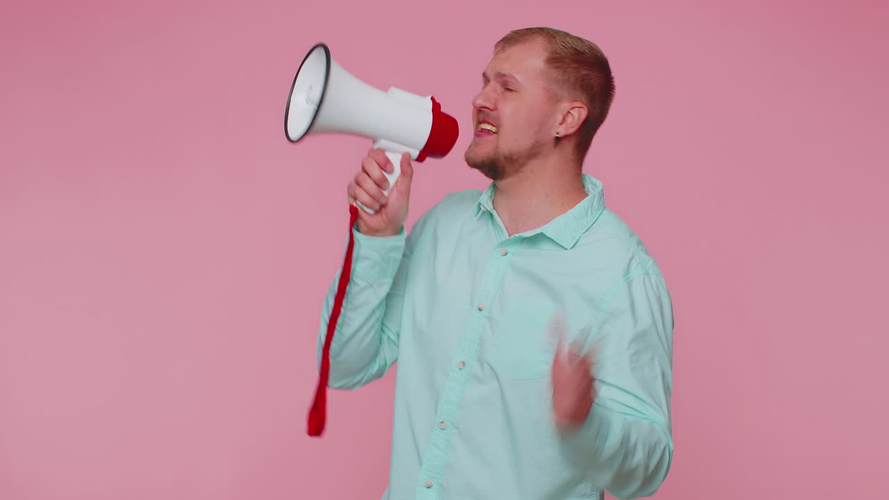 hombre barbudo sonriente hablando con megáfono, proclamando noticias, anunciando en voz alta anuncios de venta