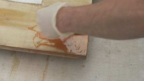 brushing out polyester resin over plywood for fiberglass