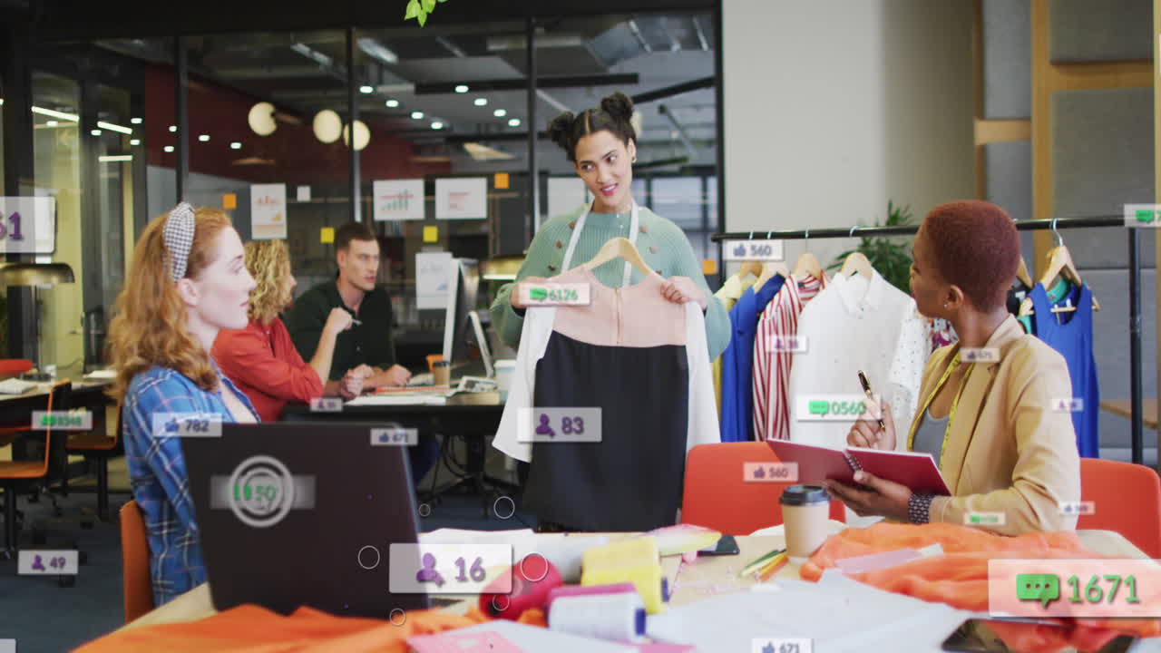 animación de los iconos de las redes sociales sobre un equipo diverso de diseñadores de moda discutiendo juntos en la oficina