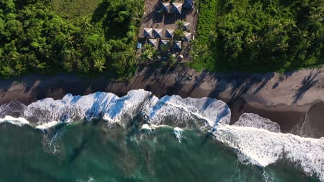 Toma-Aérea-Creciente-De-La-Playa-Y-Las-Olas-Durante-La-Puesta-De-Sol-Con-Un-Pequeño-Pueblo-En-El-Sudeste-Asiático