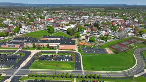 High-aerial-of-small-town-USA-with-school-campus-grounds