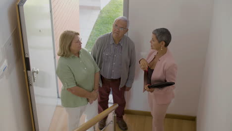 real estate agent with senior couple visiting house for buying