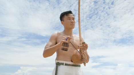 shirtless man playing instrument