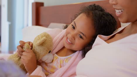 Close-up-of-black-mother-and-daughter-reading-story-book-in-a-comfortable-home-4k