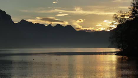 evening mist gently veils the peaceful waters of lake walensee, switzerland, casting a magical and serene ambiance across the calm, natural landscape.