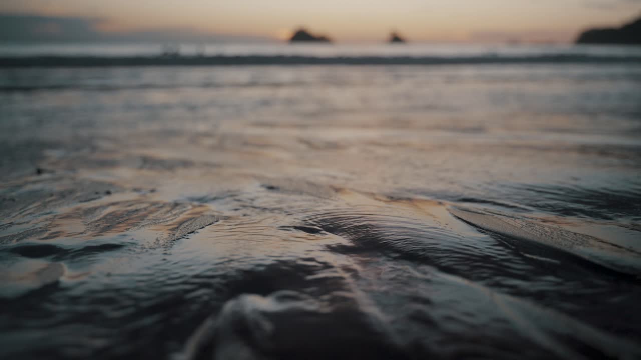Onde del mare sfocate sulla riva durante il crepuscolo.