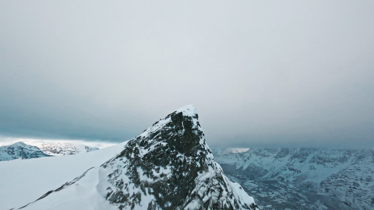 Snow-covered mountain peak in Tromsø with a cold, dramatic, and remote atmosphere