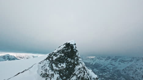 snow-covered mountain peak in tromsø with a cold, dramatic, and remote atmosphere