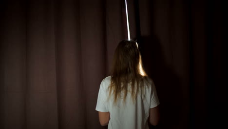 Woman-opening-curtains-and-stretching-out-in-the-morning