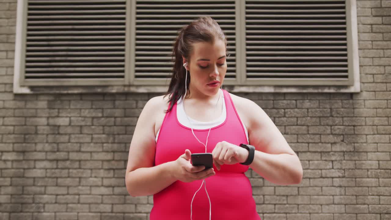 Young Caucasian woman using her phone and connected watch