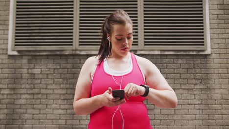 Young-Caucasian-woman-using-her-phone-and-connected-watch