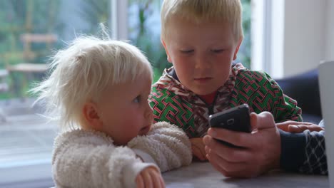 Father-and-children-using-mobile-phone-at-home-4k