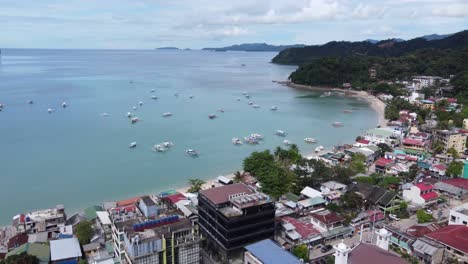 Colorful-filipino-outrigger-Boats-at-the-bay-against-El-Nido-Town-Proper,-Bacuit-Strait