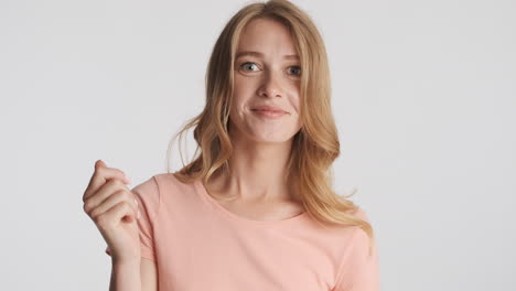 caucasian woman showing money gesture on camera.