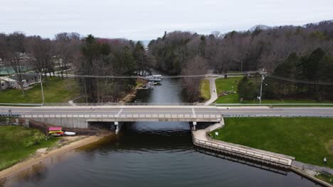 Approaching-an-old-stone-bridge-on-a-lush-late-spring-day-in-Norton-Shores,-Michigan