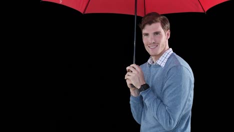 Smiling-man-under-red-umbrella-on-black-background