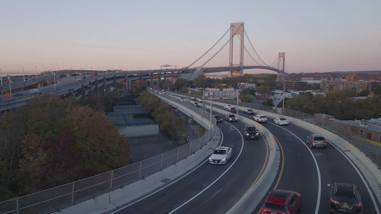 Ilmakuva liikenteestä ylittämässä Verrazano-Narrows Bridge -siltaa auringonnousun aikaan. Kuvattu syysaamuna Brooklynissa.