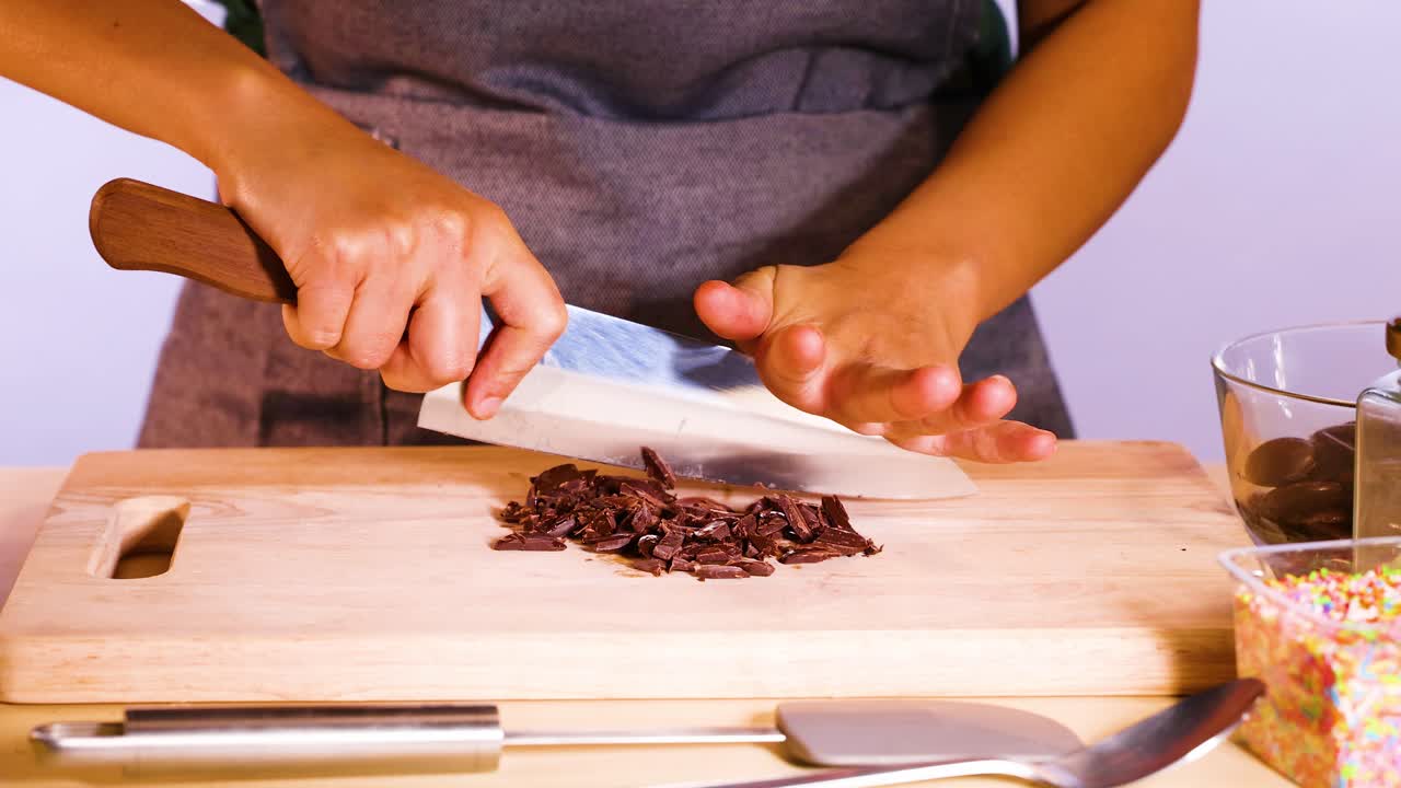 Mani che tagliano dischi di cioccolato con un coltello