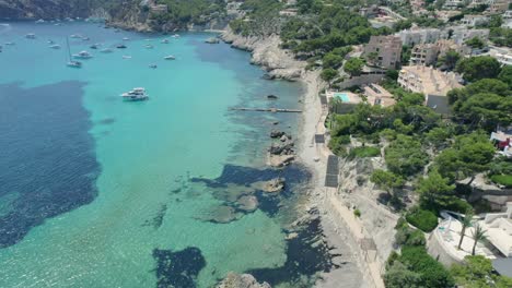 Sobrevuelo-Aéreo-De-La-Costa-De-Mallorca-Con-Hermosas-Aguas-Cristalinas-Y-Hoteles-Encaramados-En-La-Ladera