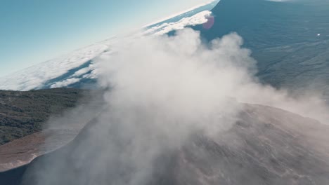 massive smoke clouds bursting from active volcano in guatemala, aerial fpv shot