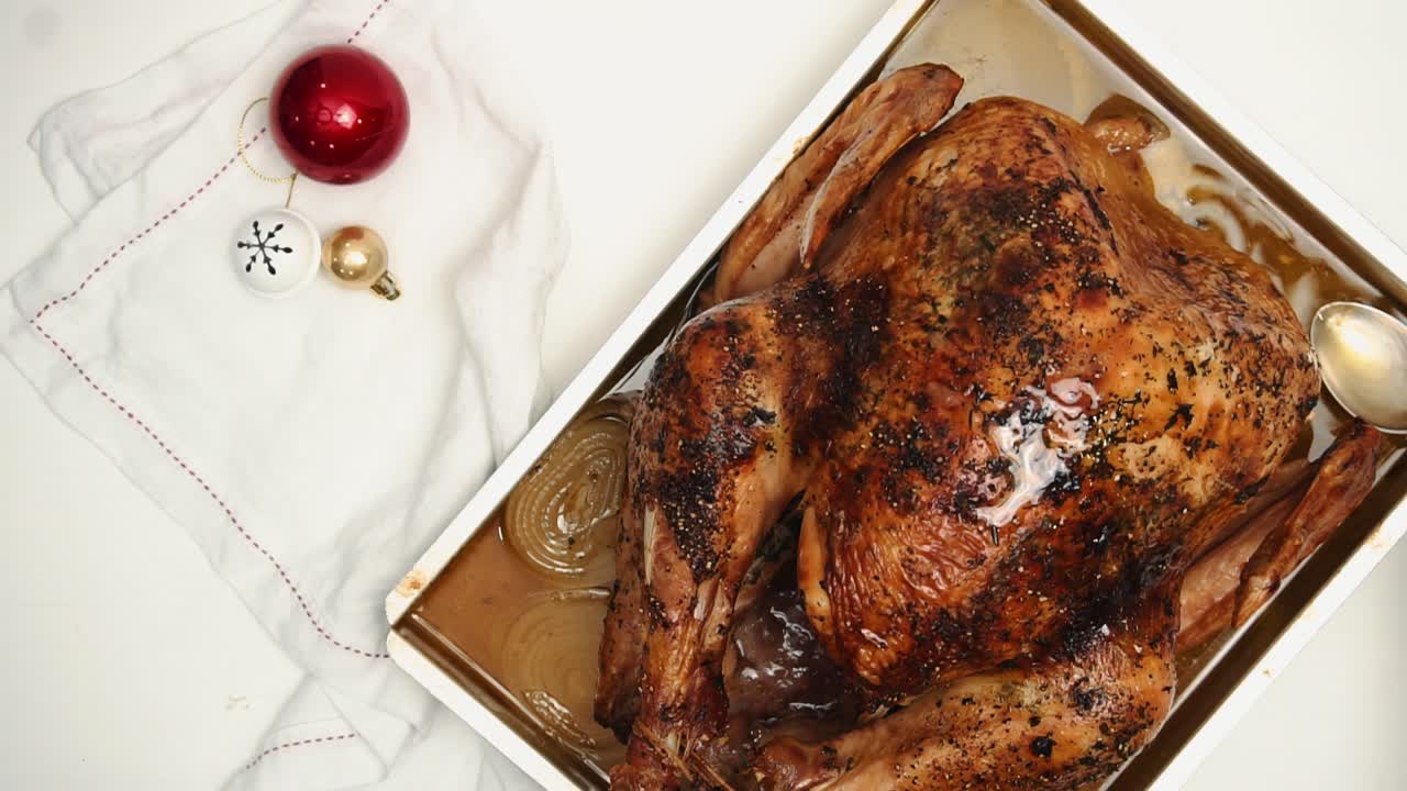 Pouring delicious oil juices over baked turkey -Christmas meal -top view