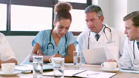 equipo médico hablando juntos mientras miran carpeta