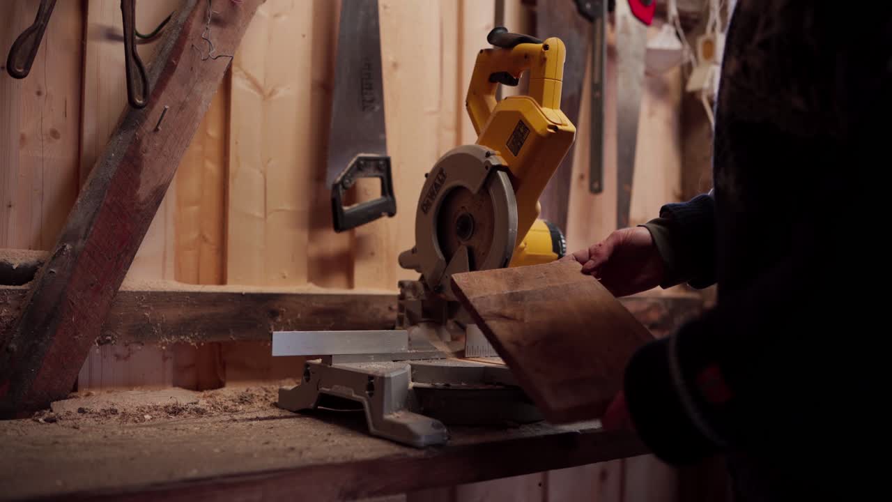 el hombre se está preparando para usar una sierra circular para cortar una tabla de madera para la construcción de una bañera de agua caliente diy - cerca