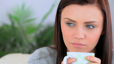 brunette woman holding a cup of coffee