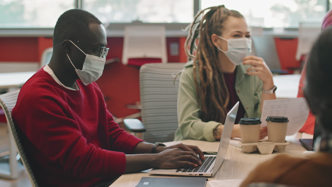 Man Working on Laptop during Meeting
