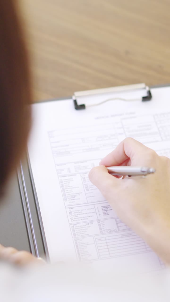 Detail of a female doctor filling a medical report