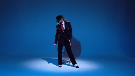 stylish man in suit and hat posing and smoking
