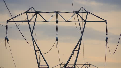 parte superior de la torre eléctrica contra el cielo amarillo nublado