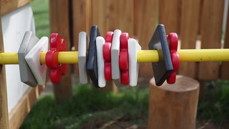 colorful wooden blocks on a yellow pole at a playground