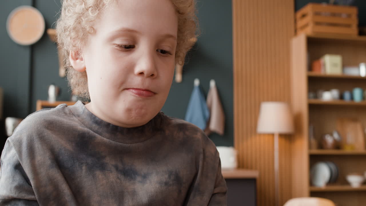 Young child drinking and using a smartphone indoors