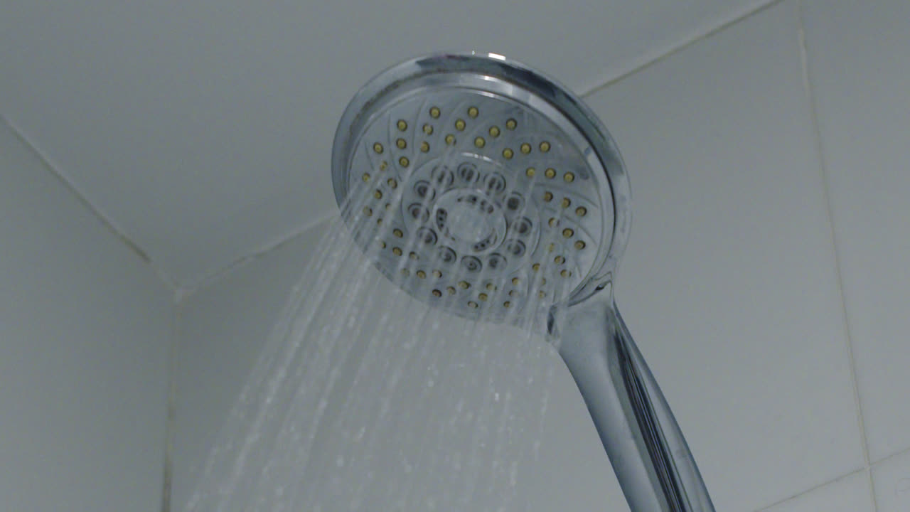 Close-up of a modern shower head spraying water
