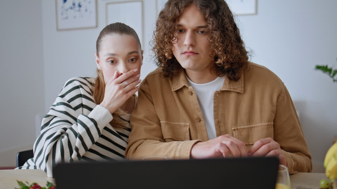 Breakfasting family watching laptop screen with confused emotions home closeup