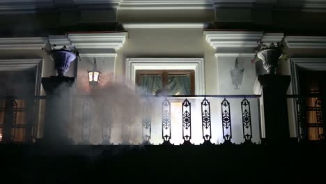 silhouette of a woman on a balcony at night