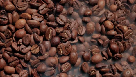 cerca de las semillas de café. los granos de café perfumados son tostados el humo viene de los granos de café.