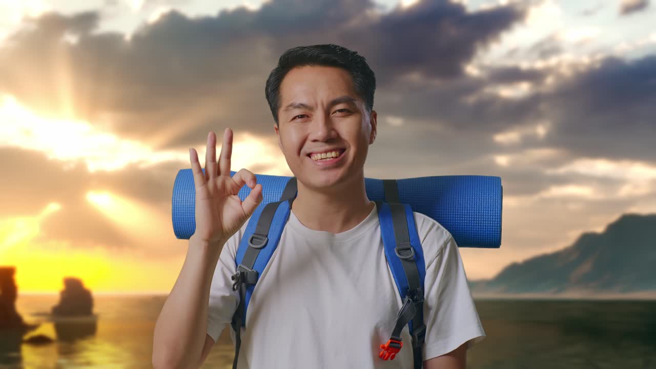 Close Up Pria Asia Pendaki Gunung Dengan Ransel Mendaki Tersenyum Dan Menunjukkan Gestur Oke Ke Kamera Di Pantai