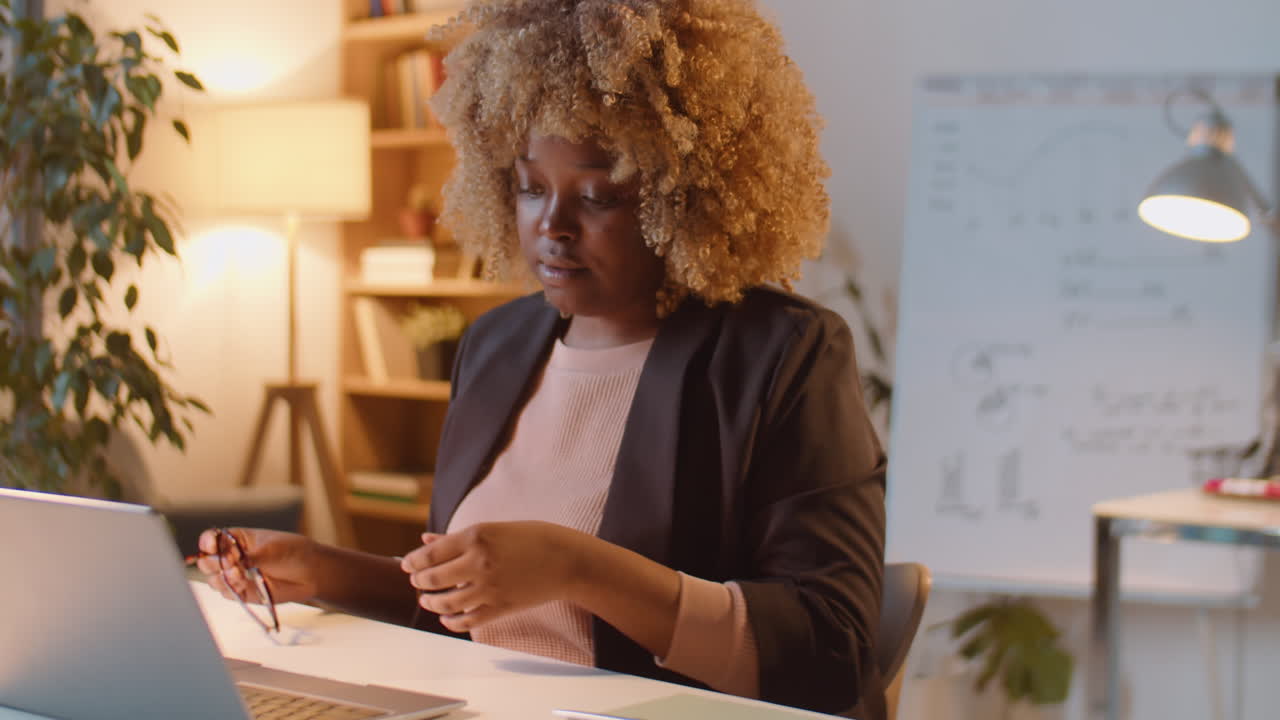 Tired Businesswoman Drinking Coffee while Working Late