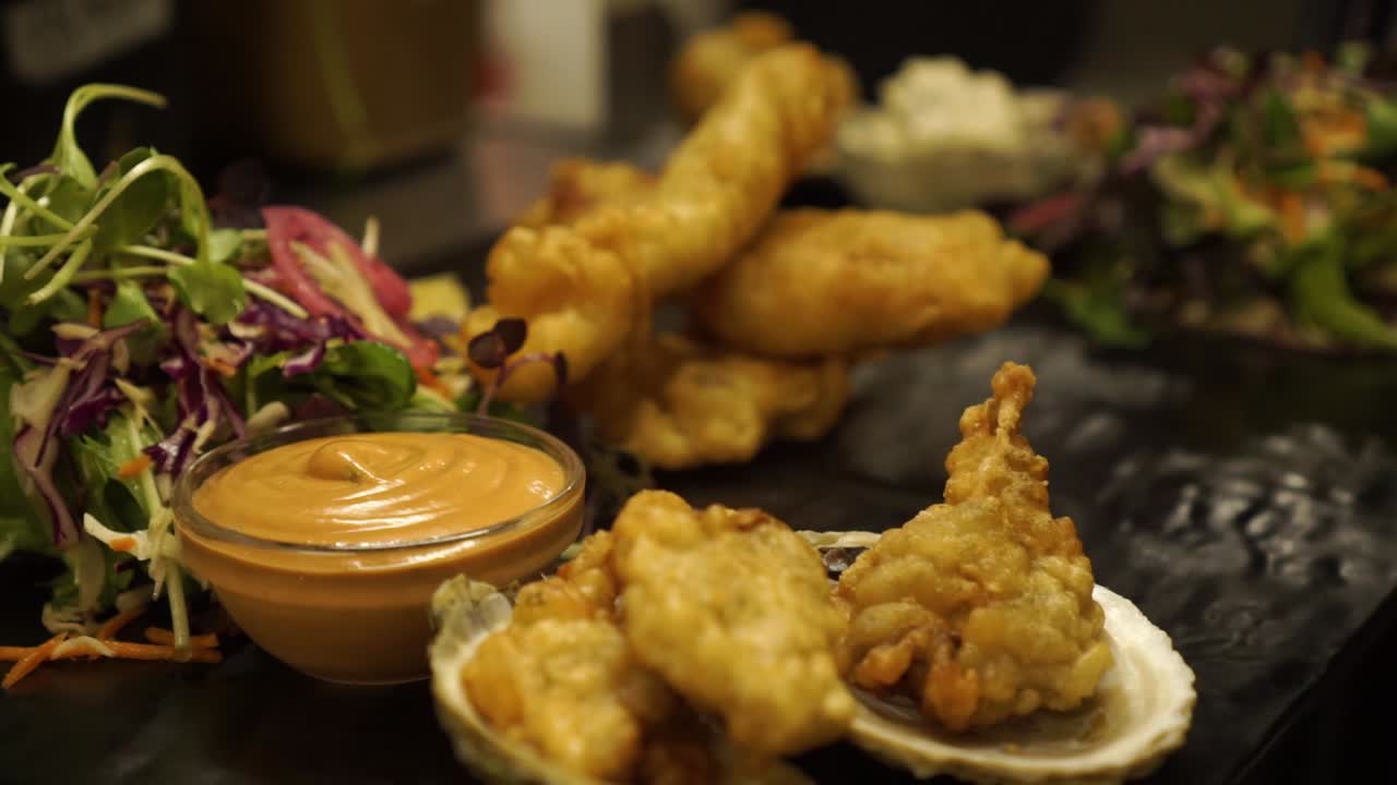 주방장이 튀긴 새우, 생선, 닭고기, 그린 샐러드, 굴, 드레싱, 그레이비를 마무리하는 요리 - 클로즈업